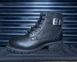 A pair of black boots sitting on top of a metal surface.