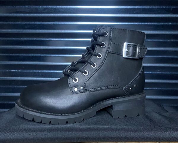 A pair of black boots sitting on top of a metal surface.