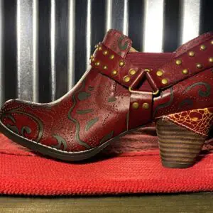 A pair of red boots sitting on top of a blanket.
