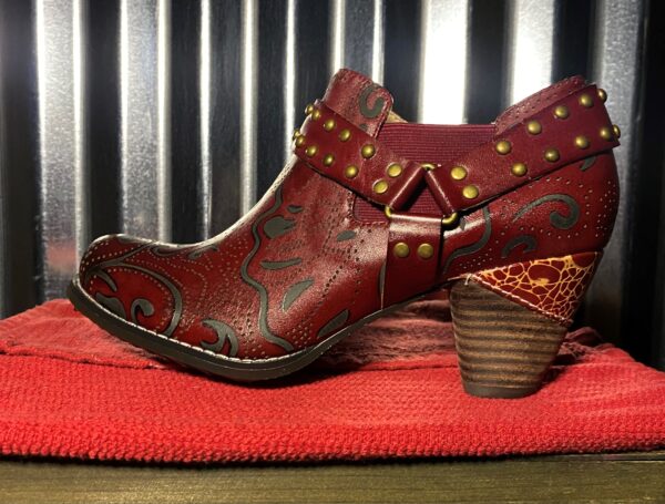 A pair of red boots sitting on top of a blanket.
