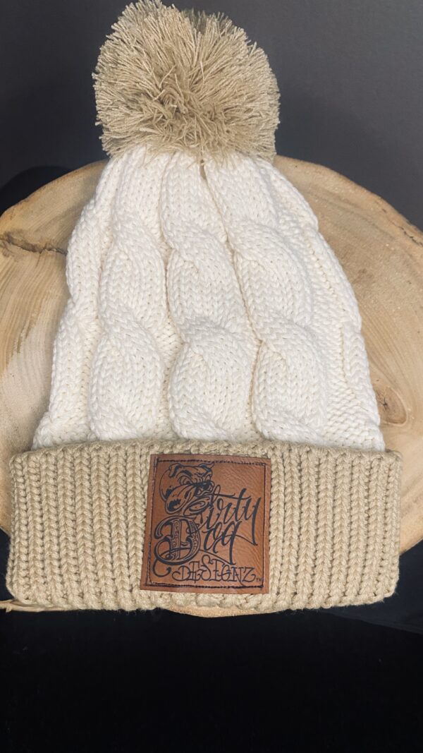 A white hat with a brown leather patch on top of it.
