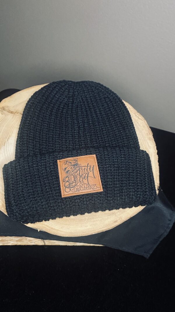 A black beanie with a leather patch on top of it.