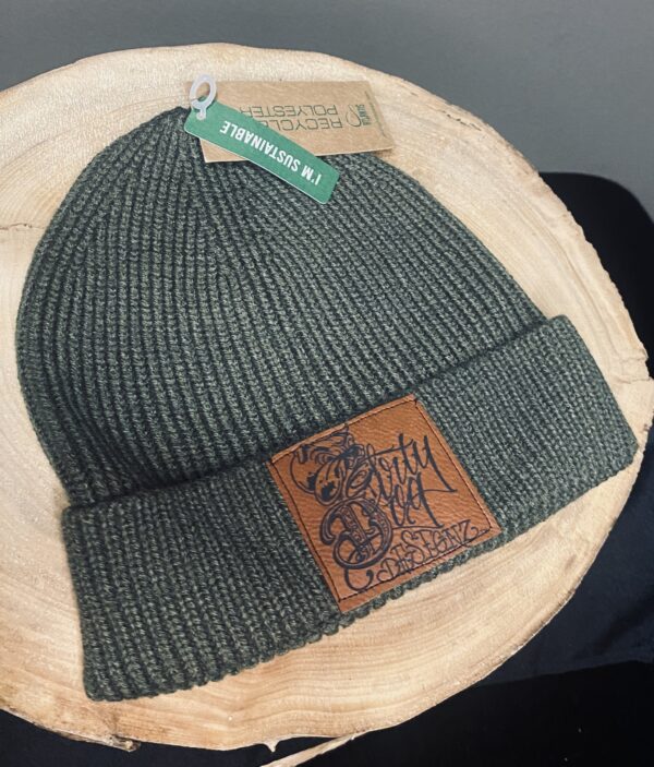 A green beanie with a leather patch on top of it.