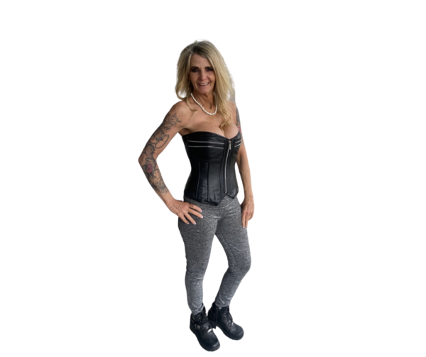 A woman in black corset and grey pants.