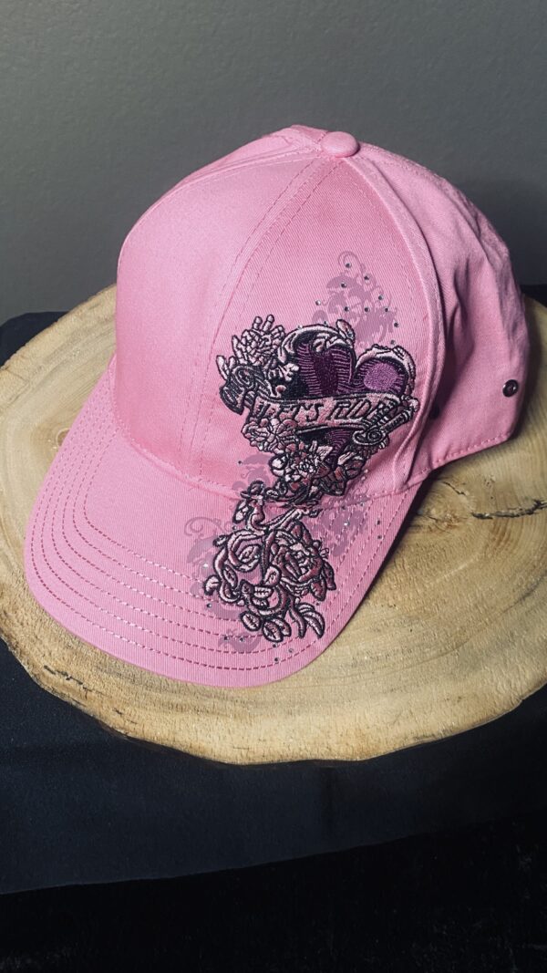 A pink hat with black and white designs on it.