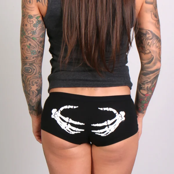 A woman with long hair and tattoos wearing black underwear.