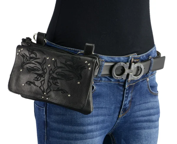 A woman wearing jeans and holding a purse.